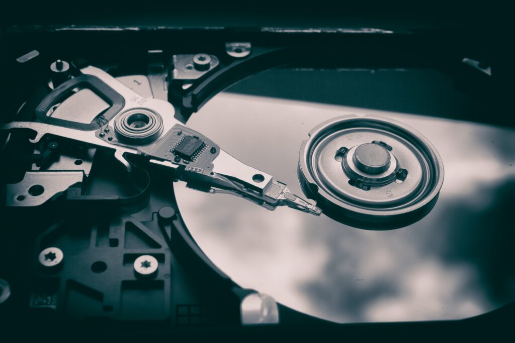 Open hard drive showing the platter and read arm